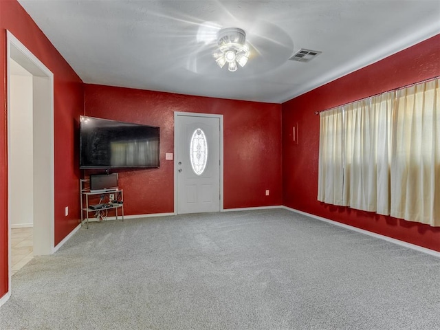 carpeted foyer with ceiling fan