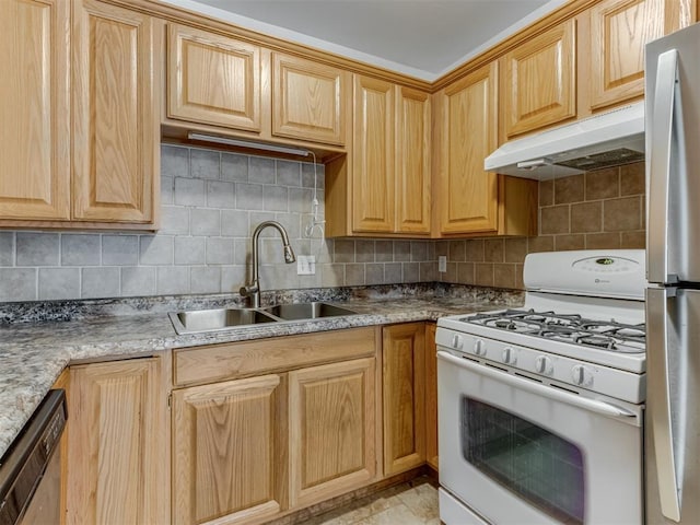 kitchen with light stone countertops, appliances with stainless steel finishes, backsplash, and sink