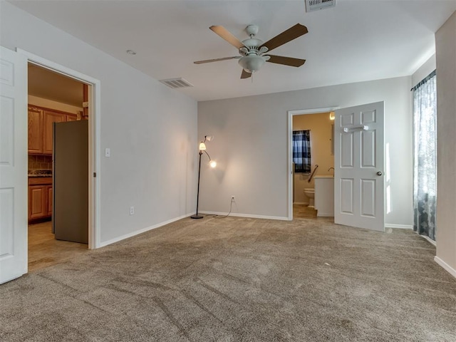 spare room featuring light colored carpet and ceiling fan