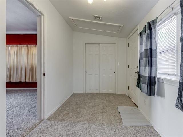 interior space with vaulted ceiling, light colored carpet, a closet, and multiple windows