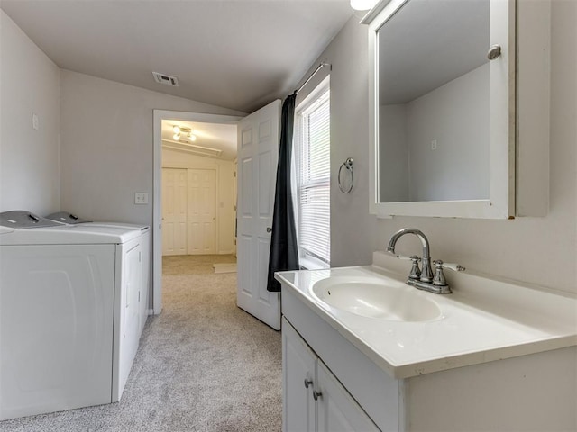 bathroom with separate washer and dryer, vanity, and vaulted ceiling