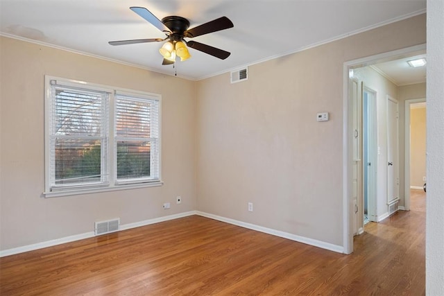 spare room featuring ceiling fan, light wood-type flooring, and crown molding