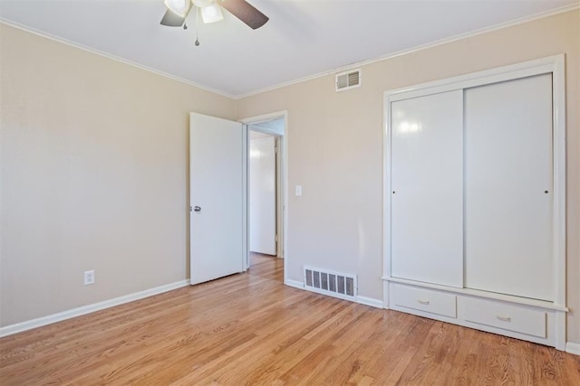 unfurnished bedroom with ceiling fan, a closet, ornamental molding, and light hardwood / wood-style flooring