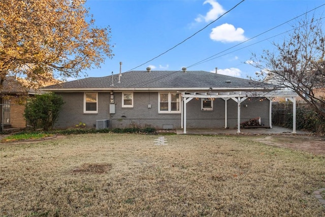 rear view of house with central AC and a lawn