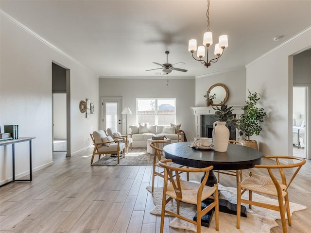 dining room featuring crown molding, light hardwood / wood-style floors, and ceiling fan with notable chandelier