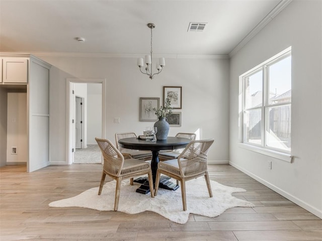 dining room with light wood-style floors, visible vents, an inviting chandelier, and ornamental molding