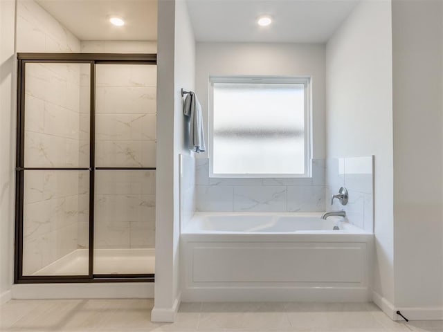 bathroom featuring a shower stall, a bath, and baseboards