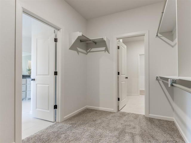 walk in closet featuring light carpet