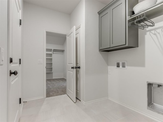 laundry room with washer hookup, cabinet space, and baseboards