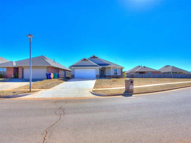 single story home featuring an attached garage, fence, and concrete driveway