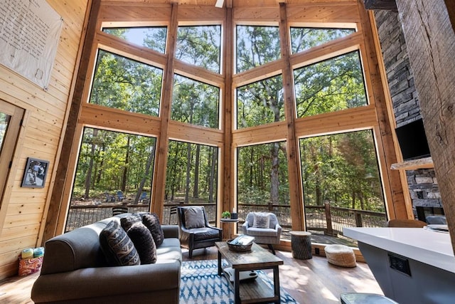 sunroom / solarium with a stone fireplace and lofted ceiling