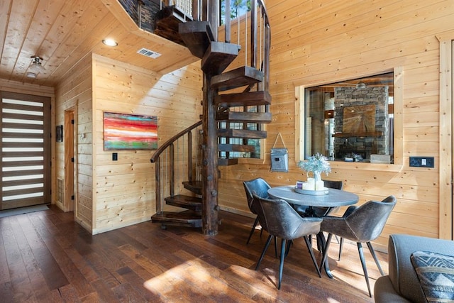 dining room featuring dark hardwood / wood-style floors, wood ceiling, and wood walls