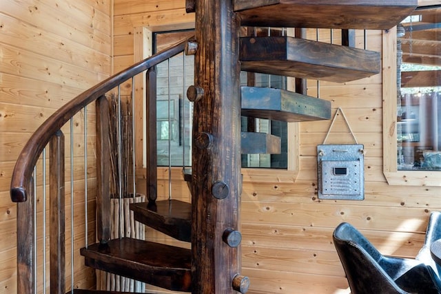 stairs featuring wood walls