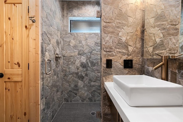 bathroom featuring a shower with door and sink