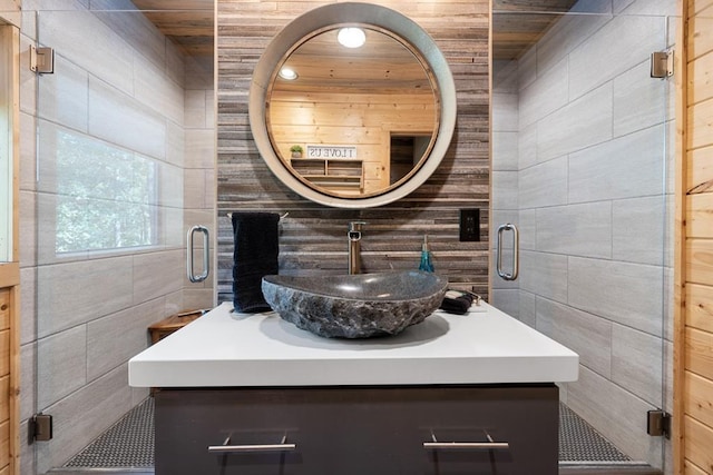 bathroom with vanity and tile walls