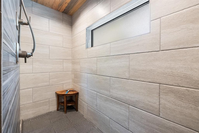 bathroom with a shower and tile walls