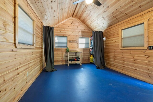 workout area with vaulted ceiling, ceiling fan, wooden ceiling, and wood walls