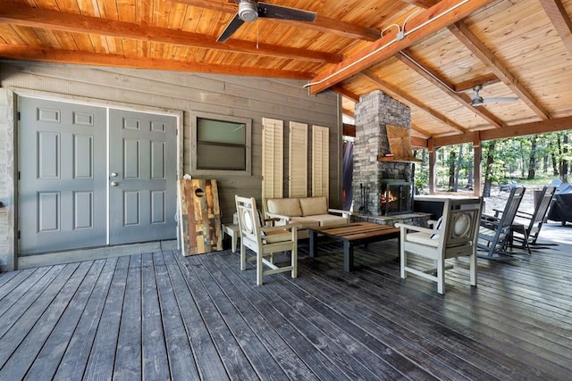 wooden deck with an outdoor living space with a fireplace and ceiling fan