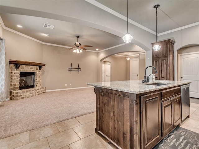 kitchen featuring ceiling fan, sink, an island with sink, light colored carpet, and dark brown cabinets