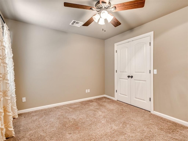 unfurnished bedroom with ceiling fan, light carpet, and a closet