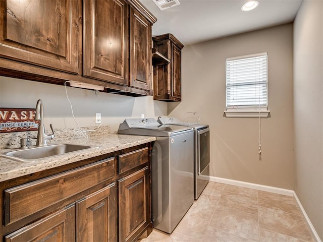 laundry room featuring cabinets, washing machine and dryer, and sink