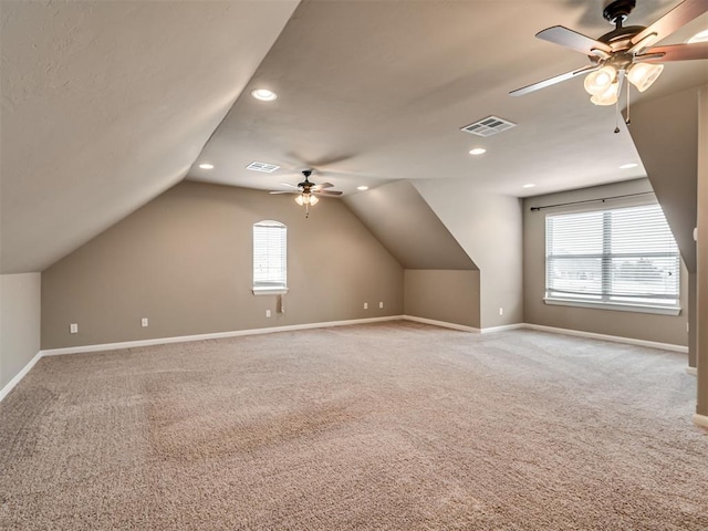 additional living space featuring carpet, ceiling fan, a wealth of natural light, and vaulted ceiling