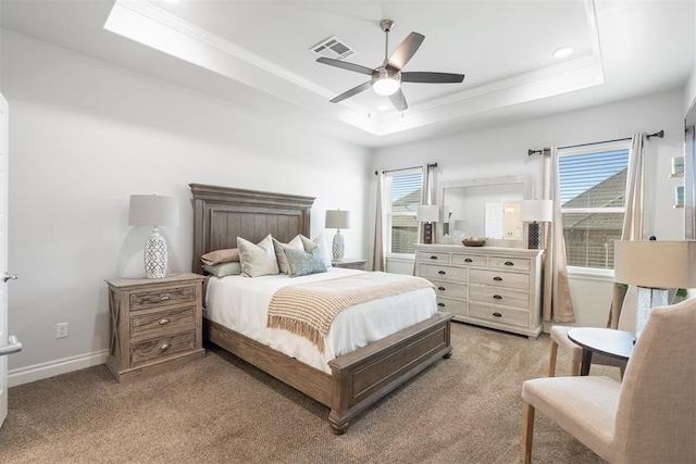 carpeted bedroom featuring ceiling fan, ornamental molding, and a tray ceiling