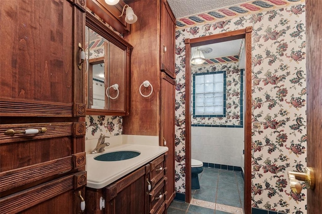 bathroom with tile patterned flooring, vanity, a textured ceiling, and toilet