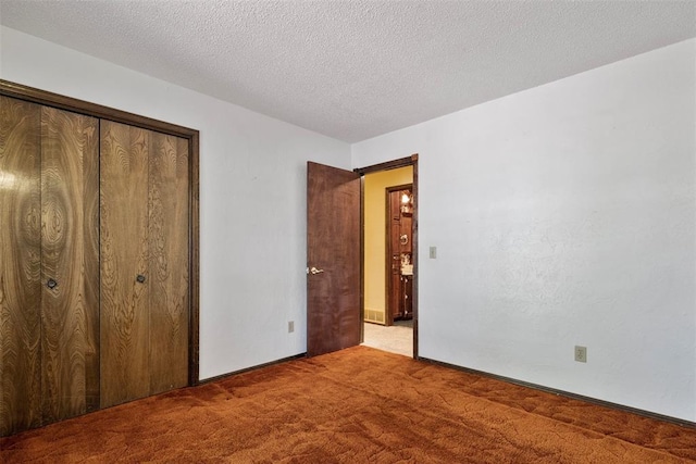 unfurnished bedroom with a textured ceiling, carpet floors, and a closet