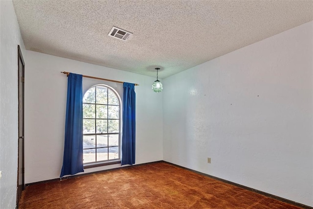 carpeted spare room featuring a textured ceiling