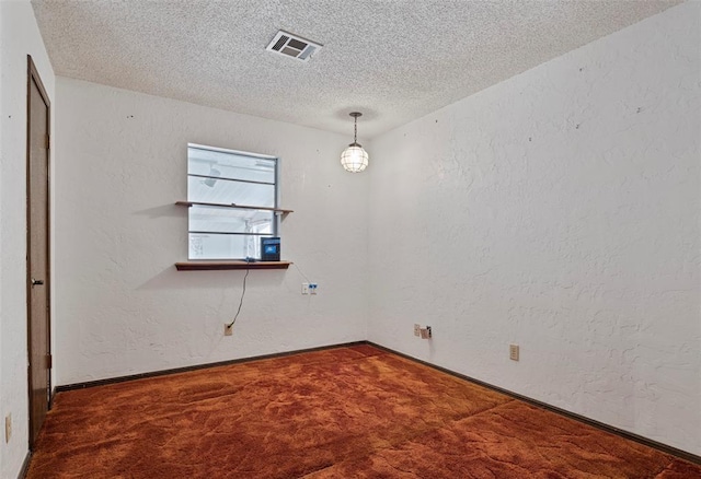 carpeted spare room with a textured ceiling