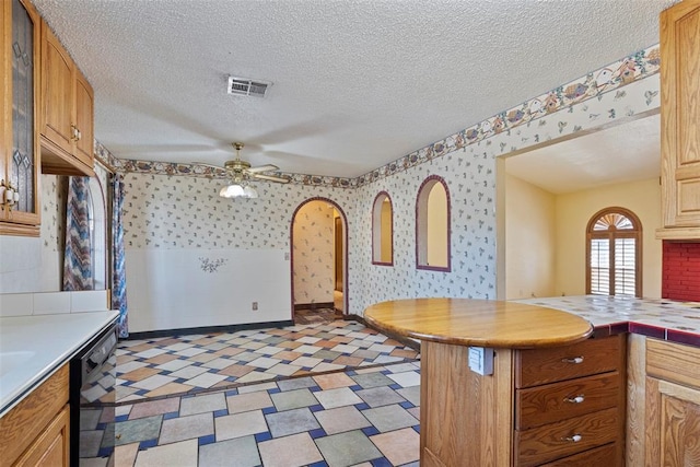 kitchen with dishwasher, a textured ceiling, kitchen peninsula, and ceiling fan