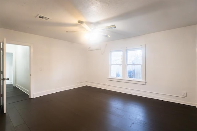 spare room featuring a textured ceiling, dark hardwood / wood-style flooring, and ceiling fan