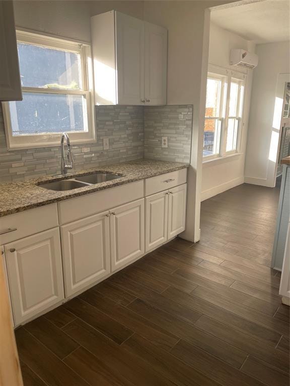 kitchen with white cabinets, tasteful backsplash, and sink