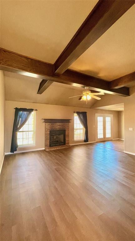 unfurnished living room featuring beamed ceiling, a wealth of natural light, and a fireplace