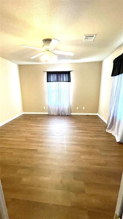 unfurnished room featuring hardwood / wood-style floors, ceiling fan, and a textured ceiling