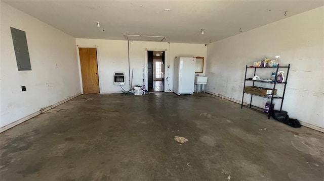 garage featuring sink, electric panel, and heating unit