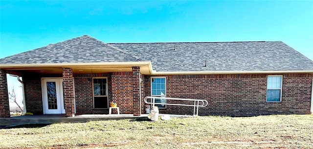 view of front facade with brick siding and a shingled roof