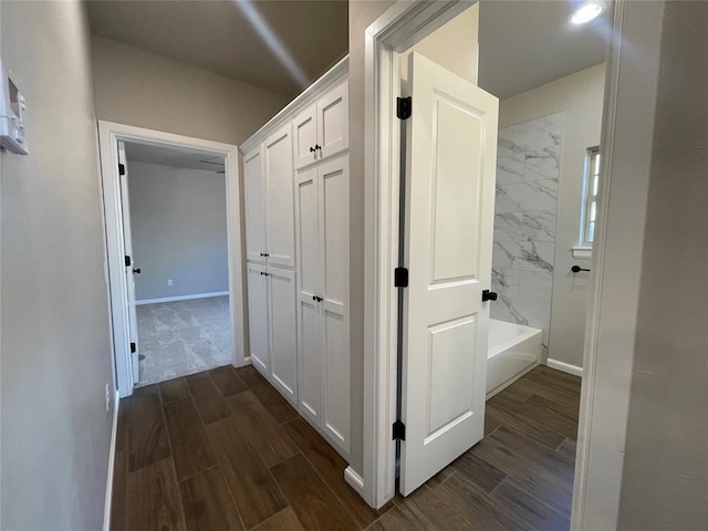 corridor with wood tiled floor and baseboards