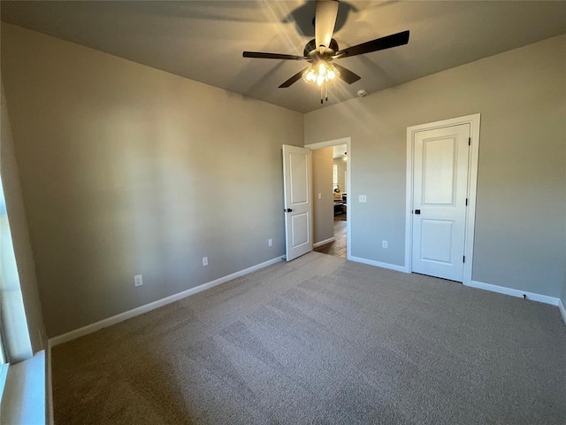 unfurnished bedroom with carpet floors, a ceiling fan, and baseboards