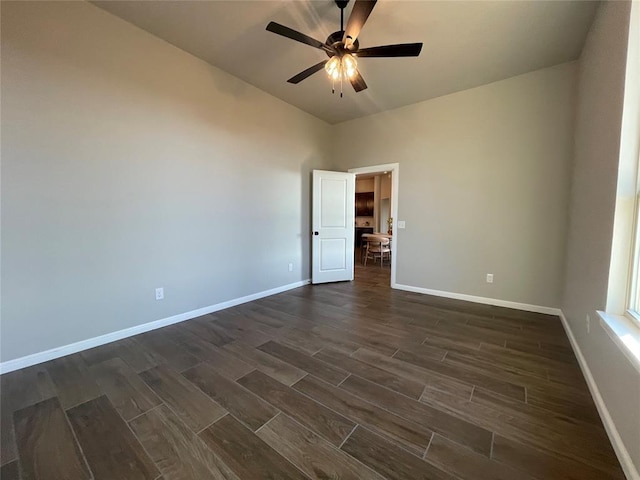 spare room featuring a ceiling fan, wood finish floors, and baseboards