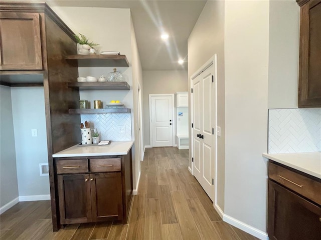 bar with light wood finished floors, recessed lighting, decorative backsplash, and baseboards