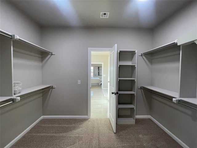 walk in closet with carpet floors and visible vents