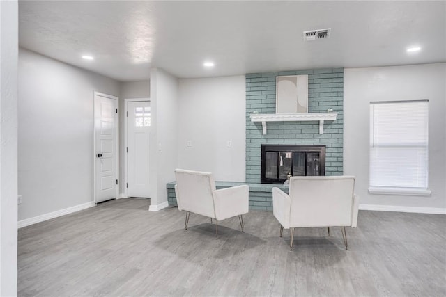 living room featuring hardwood / wood-style flooring and a brick fireplace