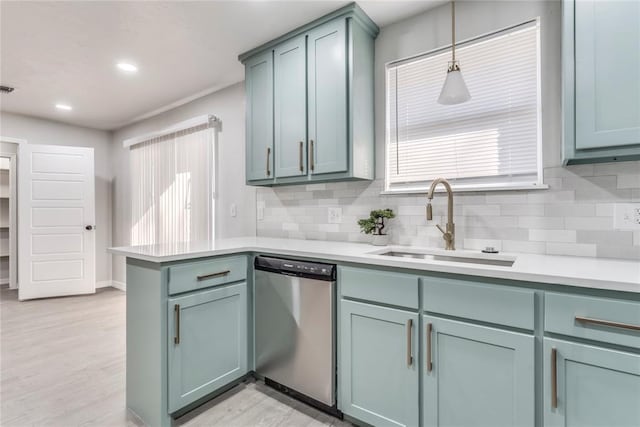 kitchen featuring dishwasher, sink, hanging light fixtures, and tasteful backsplash