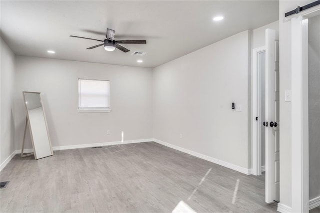 spare room featuring ceiling fan and light hardwood / wood-style flooring