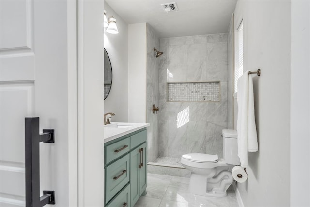 bathroom featuring toilet, vanity, and tiled shower