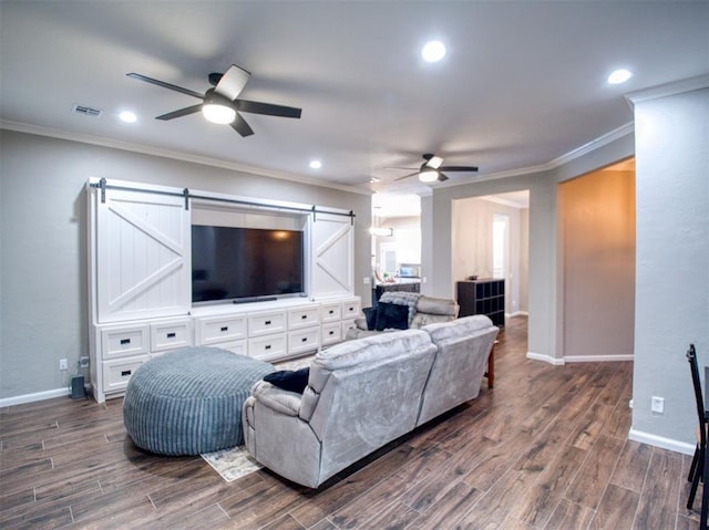 living room with a barn door, ceiling fan, and ornamental molding