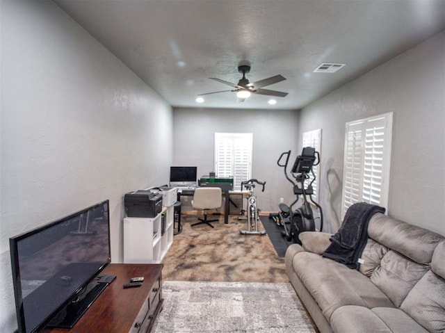 carpeted office space with ceiling fan