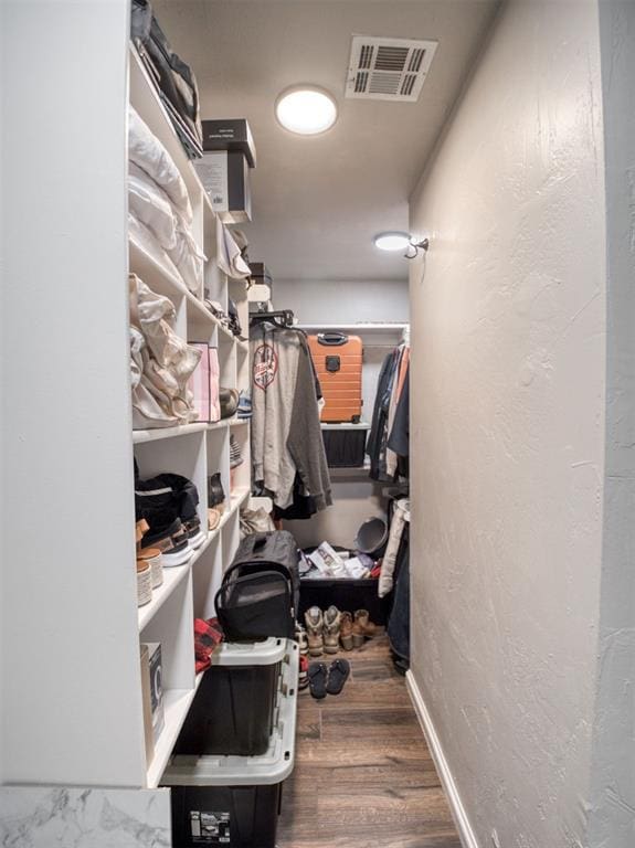 spacious closet featuring dark hardwood / wood-style flooring